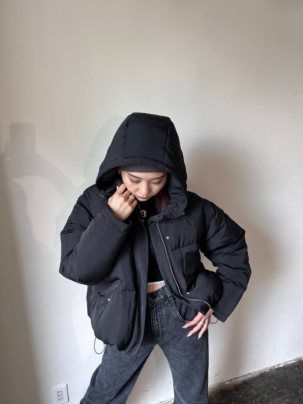 ブラック系のブルゾン、ブラック系のデニムパンツ、ブラック系のブーツを着用したレディースの秋コーディネートの3枚目の写真