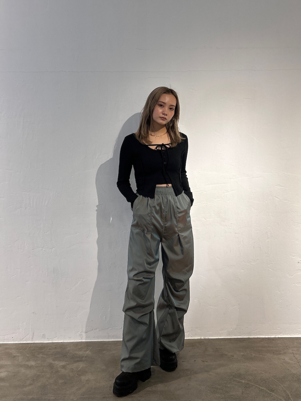 ブラック系のTシャツ/カットソー、グリーン系のその他パンツ、ブラック系のブーツを着用したレディースの冬コーディネートの3枚目の写真