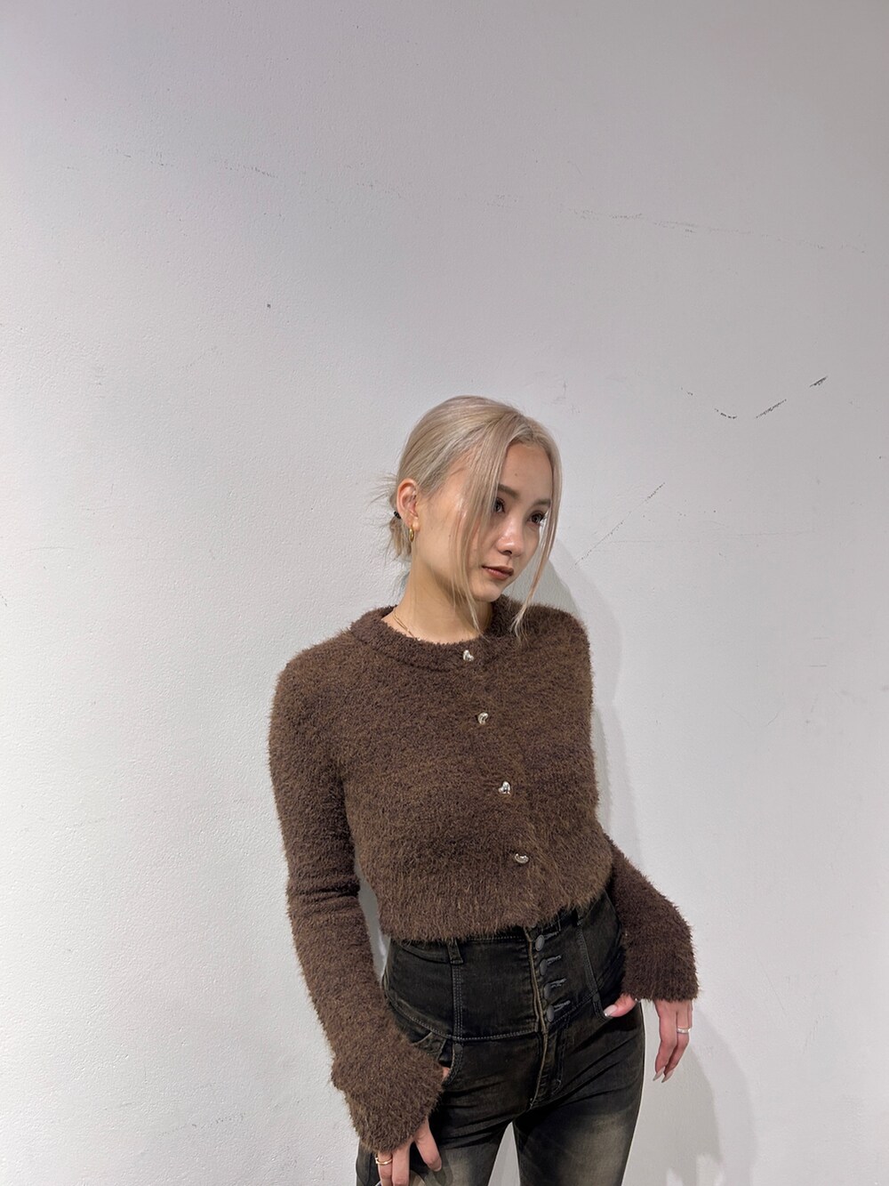 ブラウン系のニット/セーター、ブラック系のデニムパンツ、ブラック系のハンドバッグを着用したレディースの秋コーディネートの3枚目の写真