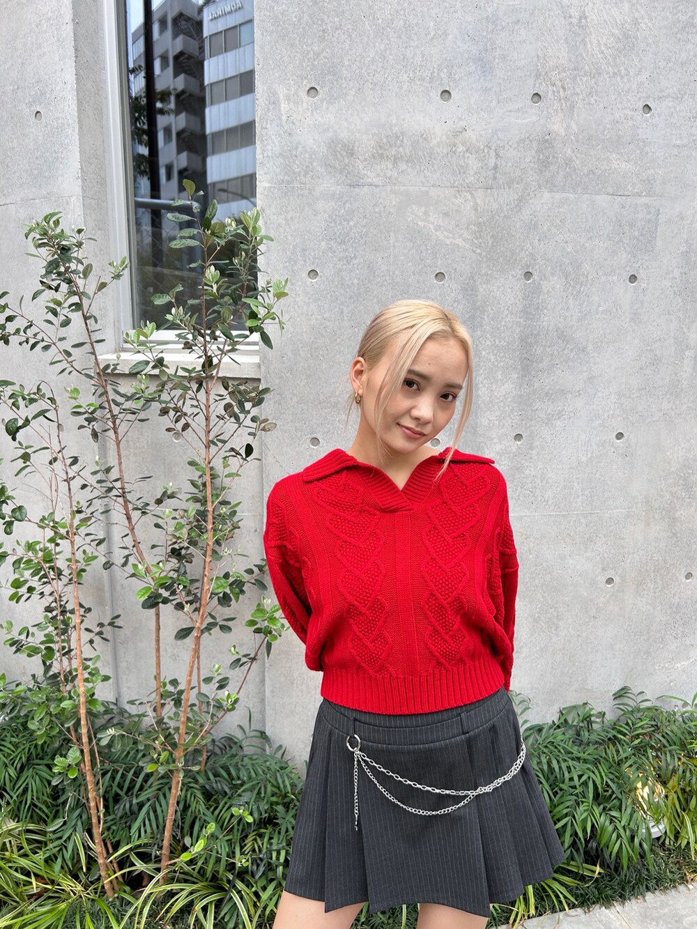 レッド系のニット/セーター、ブラック系のブーツを着用したレディースの秋コーディネートの4枚目の写真