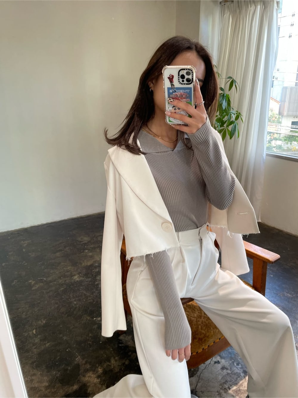 ホワイト系のテーラードジャケット、グレー系のニット/セーターを着用したレディースの冬コーディネートの2枚目の写真