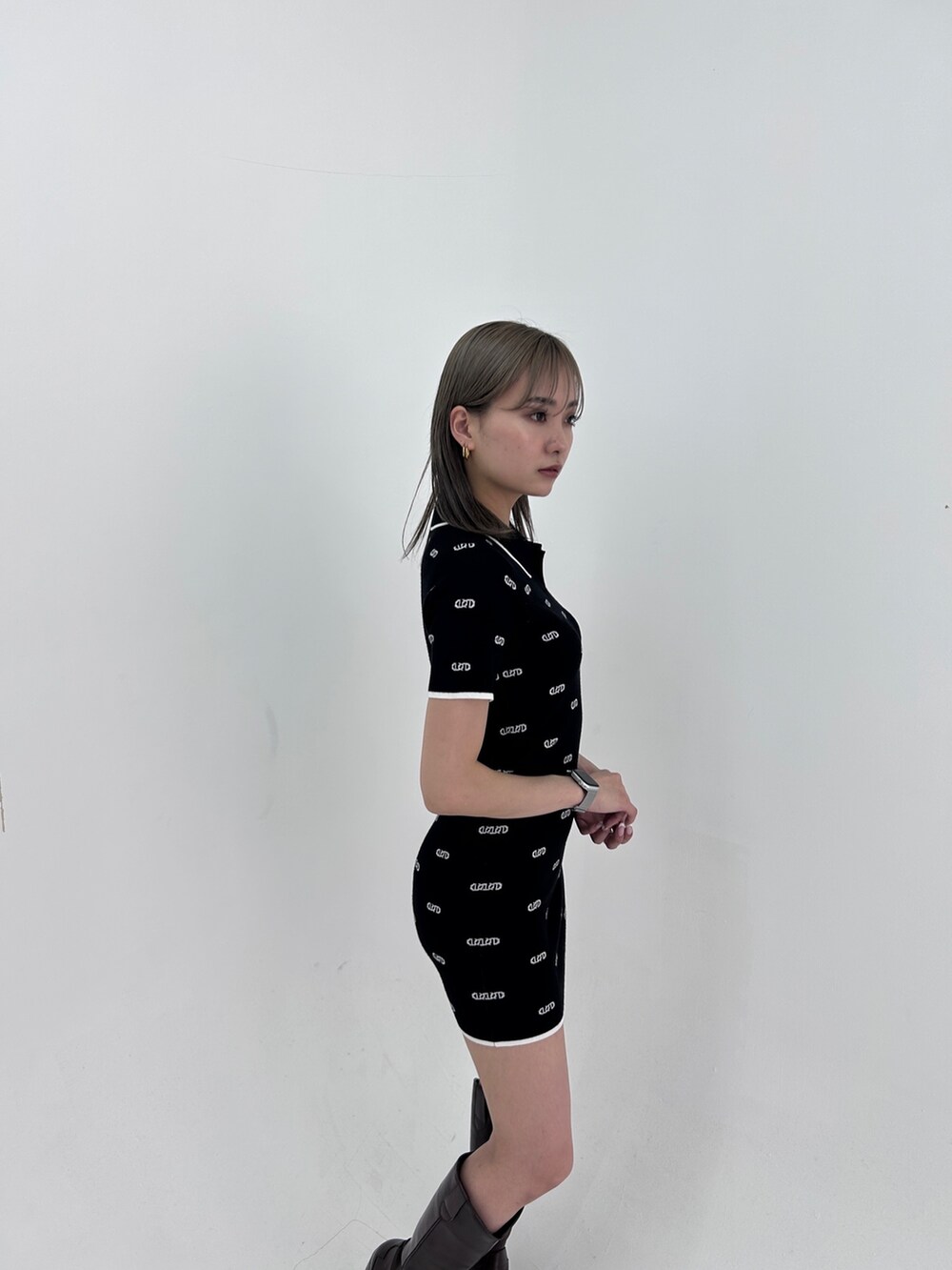 ブラック系のワンピース、ブラック系のブーツを着用したレディースの春コーディネートの4枚目の写真