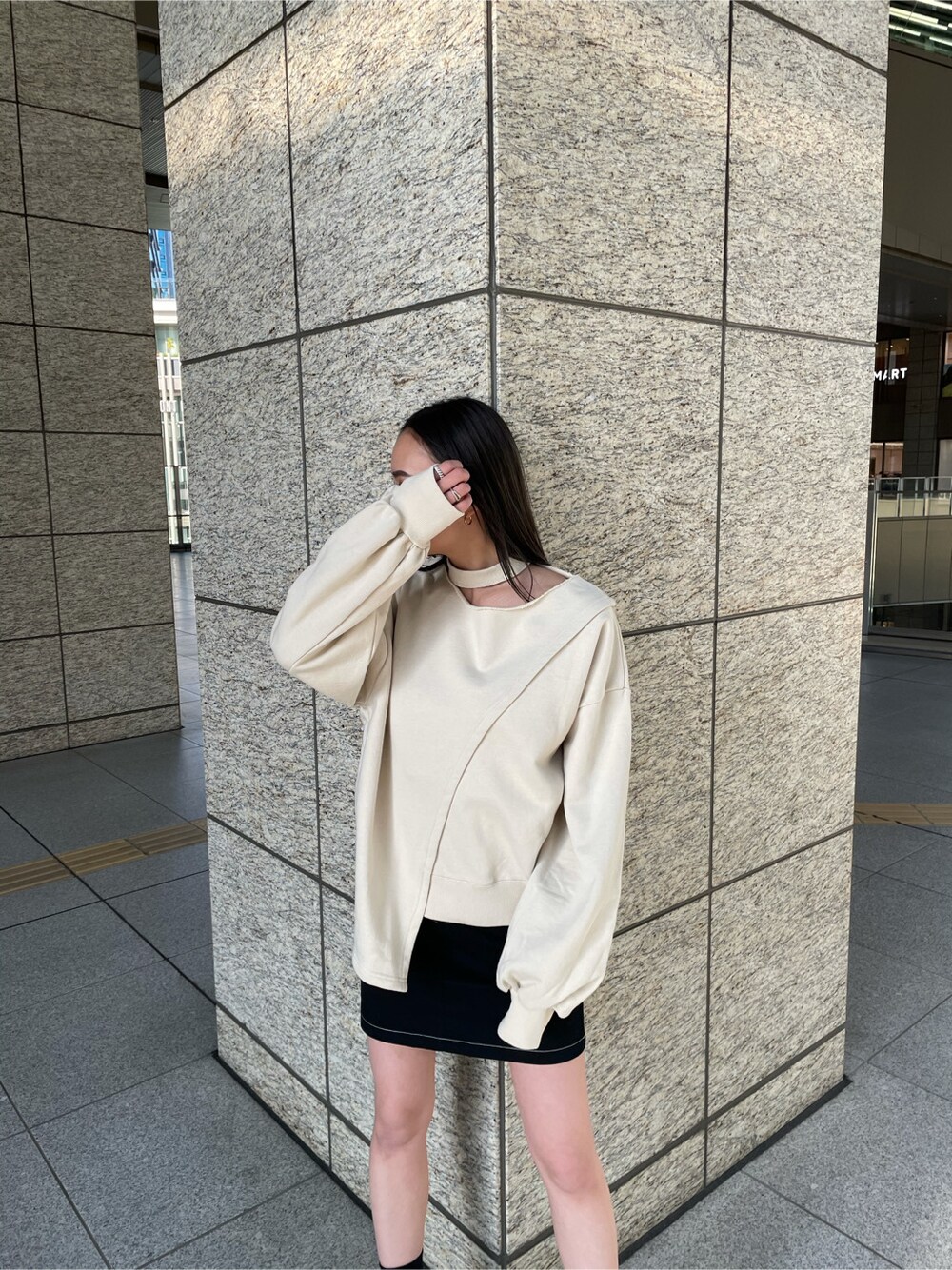 ブラック系のスカート、ホワイト系のスウェットを着用したレディースの春コーディネートの2枚目の写真