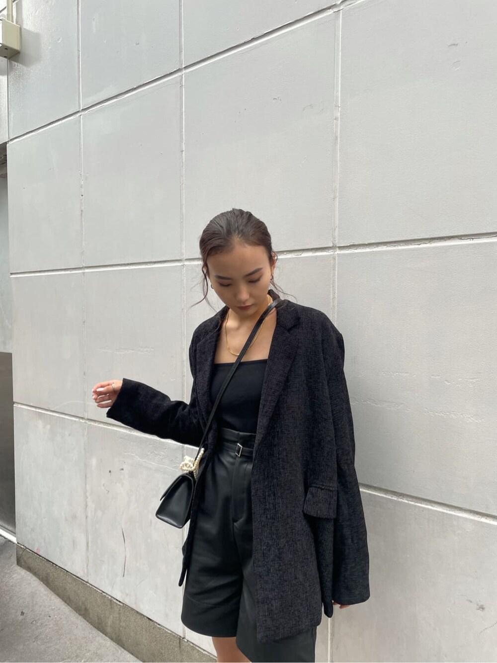 ブラック系のキャミソール、ブラック系のテーラードジャケット、ブラック系のその他パンツを着用したレディースの秋コーディネートの4枚目の写真