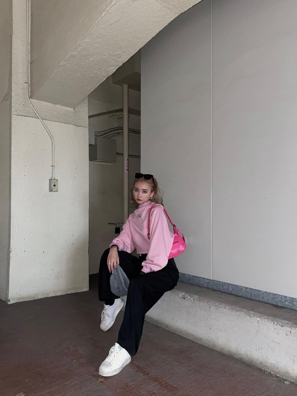 ピンク系のスウェット、ブラック系のその他パンツを着用したレディースの冬コーディネートの2枚目の写真