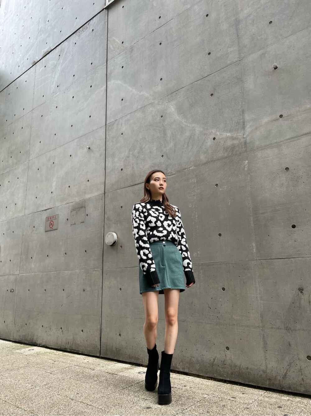 ブラック系のニット/セーター、ブラック系のブーツ、グリーン系のスカートを着用したレディースの冬コーディネートの5枚目の写真