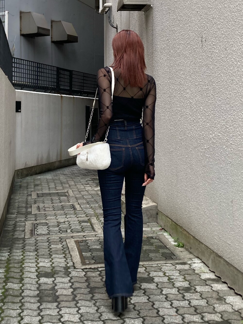 ブラック系のデニムパンツ、ブラック系のTシャツ/カットソーを着用したレディースの秋コーディネートの2枚目の写真