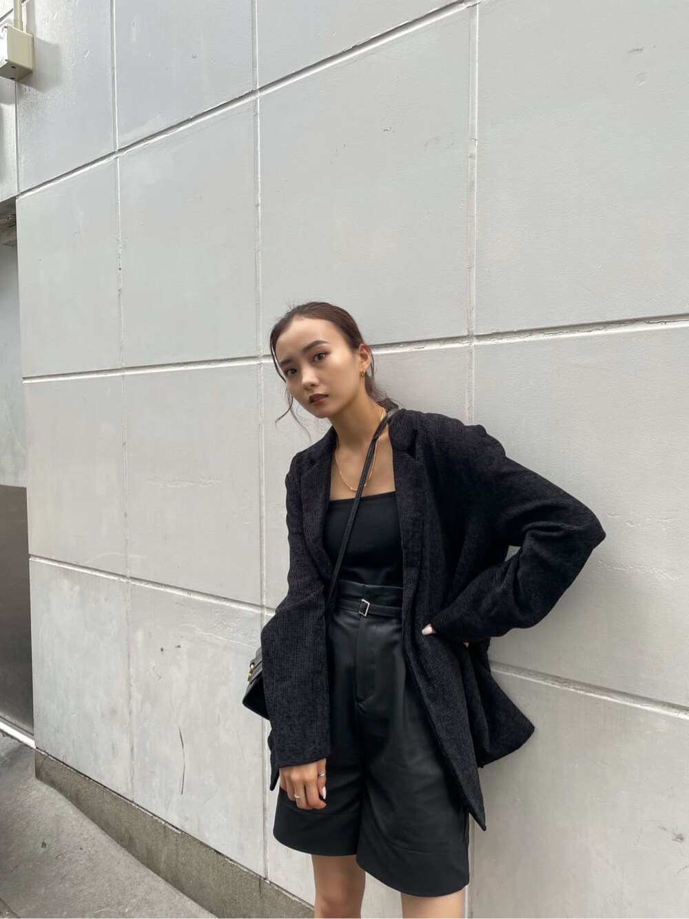 ブラック系のキャミソール、ブラック系のテーラードジャケット、ブラック系のその他パンツを着用したレディースの秋コーディネートの3枚目の写真