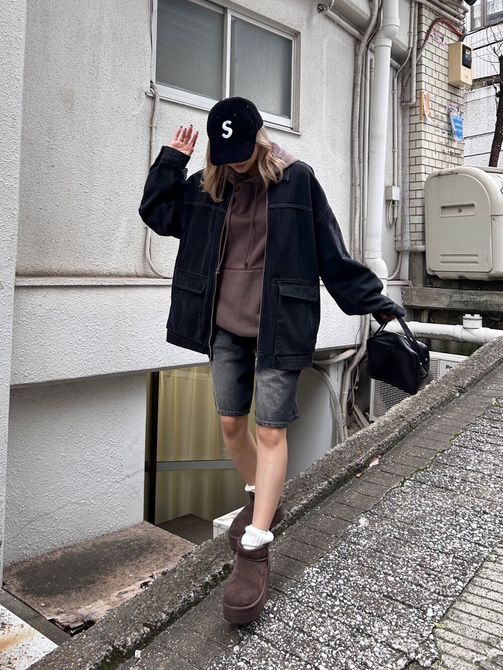 ブラック系のブルゾン、ブラック系のデニムパンツ、ブラウン系のスウェットを着用したレディースの秋コーディネートの2枚目の写真