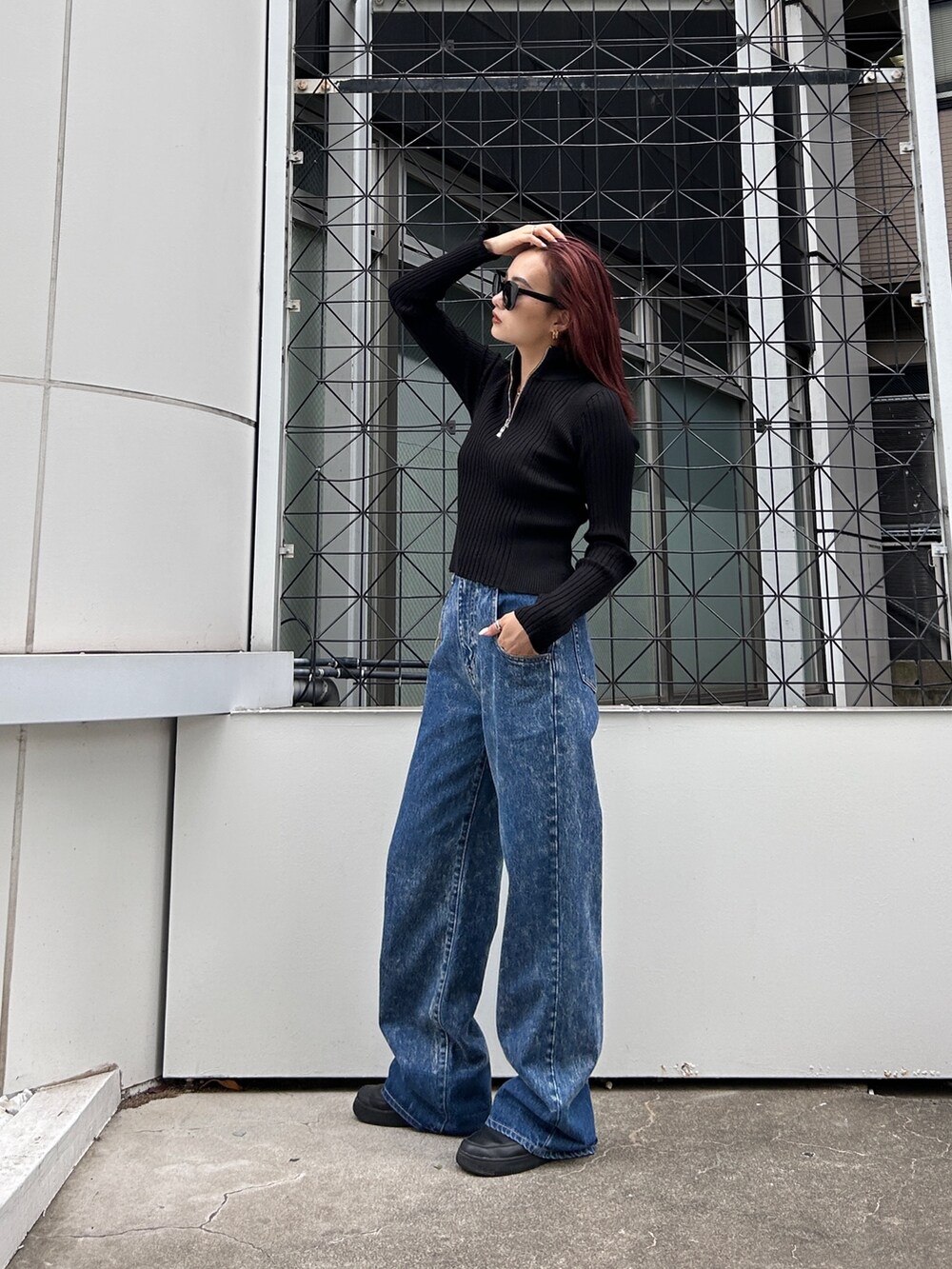 ブラック系のニット/セーター、ブルー系のデニムパンツを着用したレディースの秋コーディネートの3枚目の写真