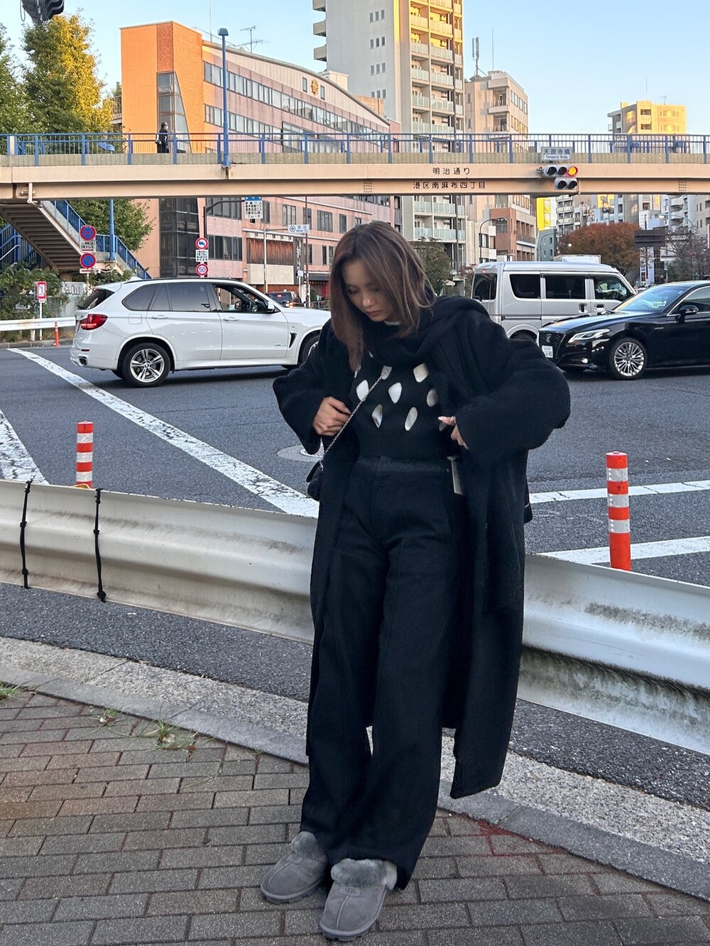 ブラック系のチェスターコート、ブラック系のデニムパンツを着用したレディースの冬コーディネートの2枚目の写真