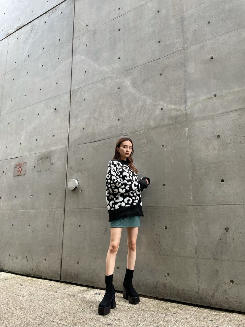 ブラック系のニット/セーター、ブラック系のブーツ、グリーン系のスカートを着用したレディースの冬コーディネートの3枚目の写真