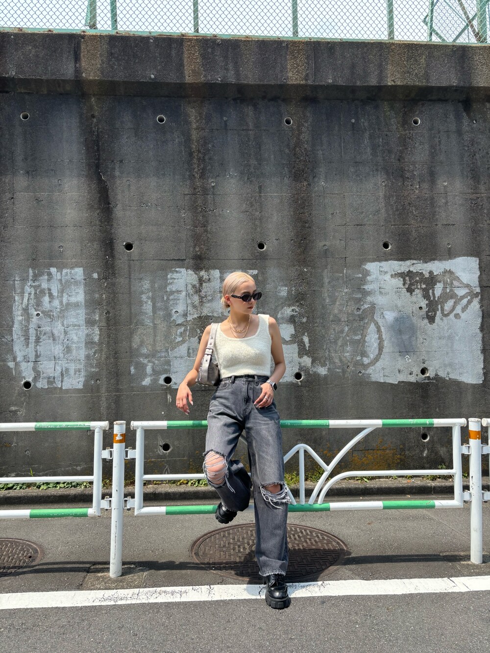 ホワイト系のニット/セーター、グレー系のデニムパンツ、シルバー系のハンドバッグを着用したレディースの夏コーディネートの3枚目の写真