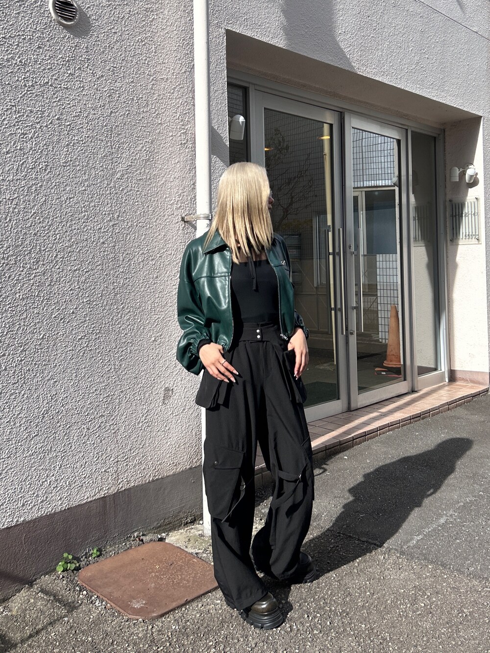 グリーン系のブルゾン、ブラック系のその他パンツを着用したレディースの冬コーディネートの3枚目の写真