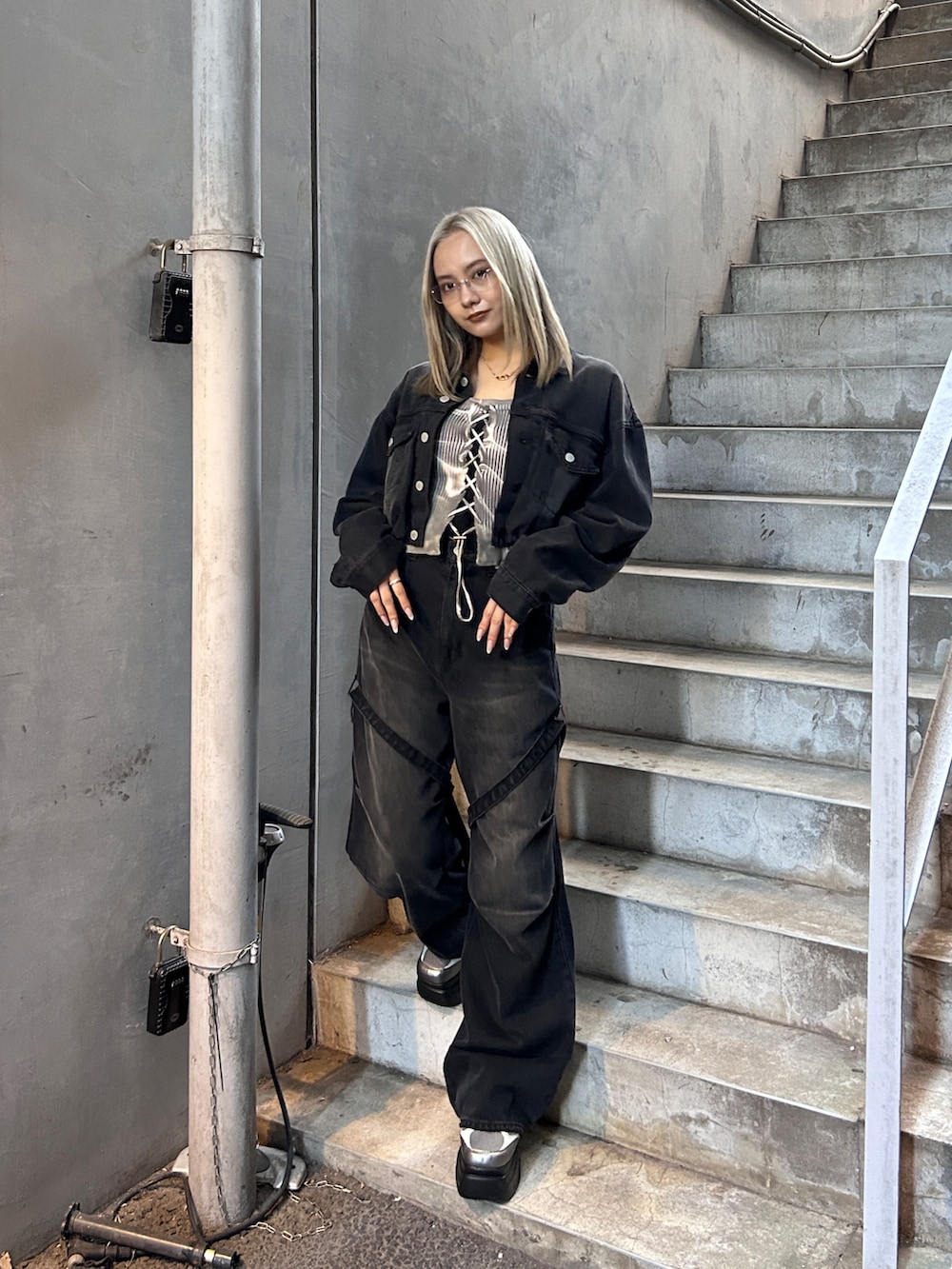 ブラック系のデニムジャケット、ブラック系のデニムパンツ、シルバー系のスニーカーを着用したレディースの冬コーディネートの2枚目の写真