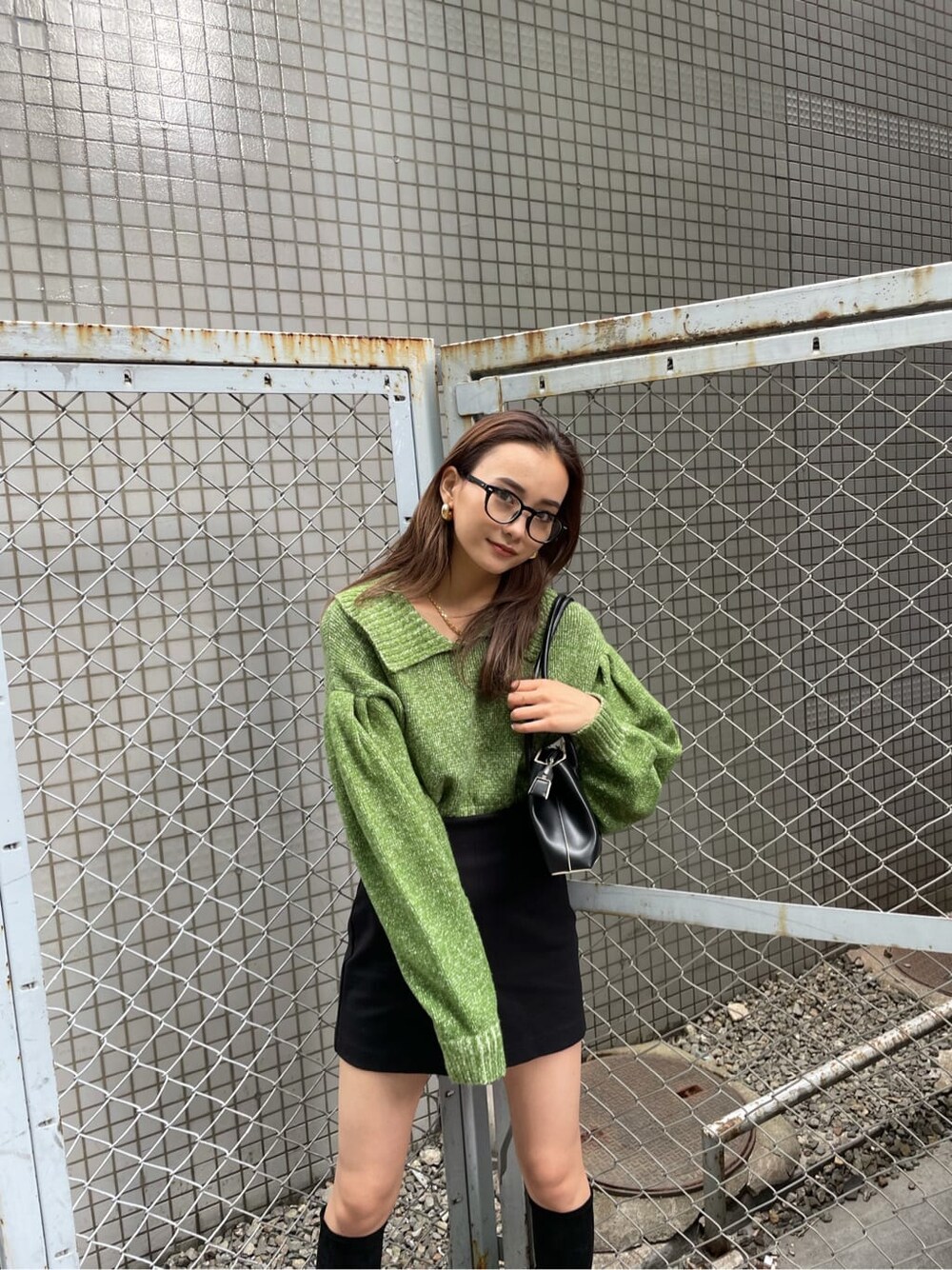 ブラック系のスカート、グリーン系のニット/セーターを着用したレディースの冬コーディネートの3枚目の写真