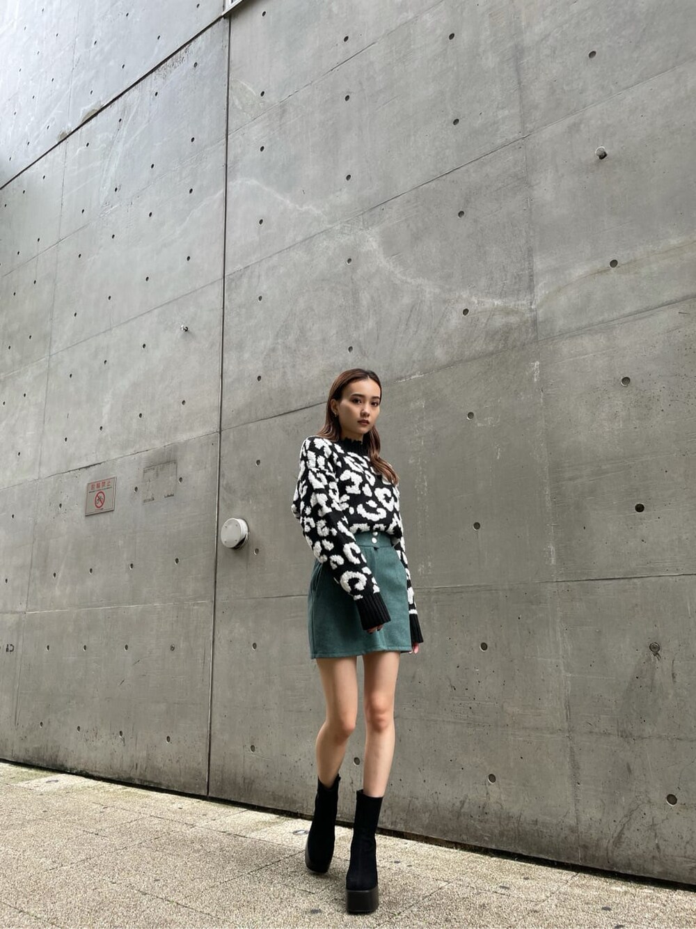 ブラック系のニット/セーター、ブラック系のブーツ、グリーン系のスカートを着用したレディースの冬コーディネートの4枚目の写真