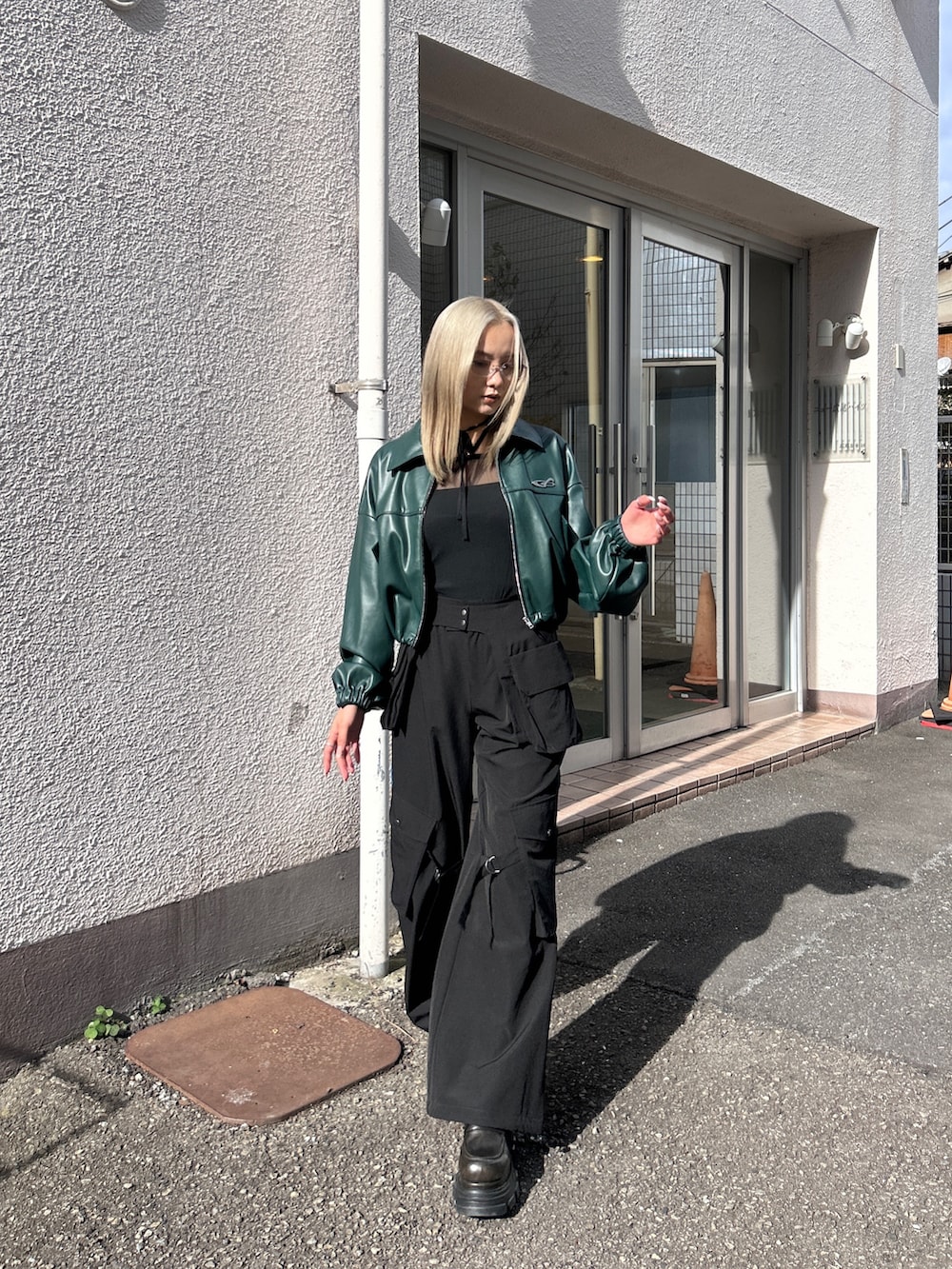 グリーン系のブルゾン、ブラック系のその他パンツを着用したレディースの冬コーディネートの4枚目の写真