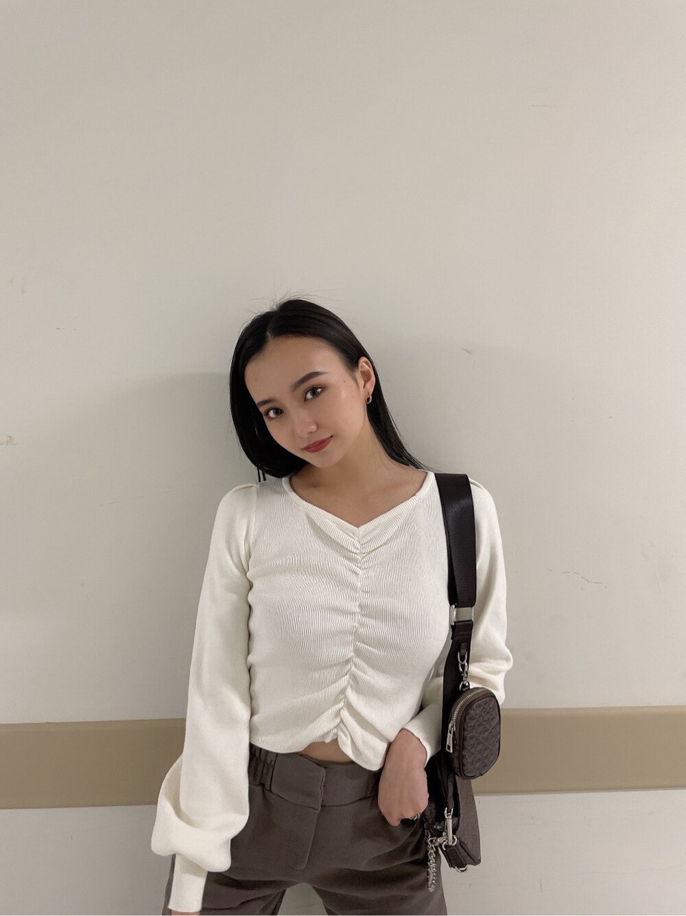 グレー系のその他パンツ、ホワイト系のニット/セーターを着用したレディースの冬コーディネートの2枚目の写真