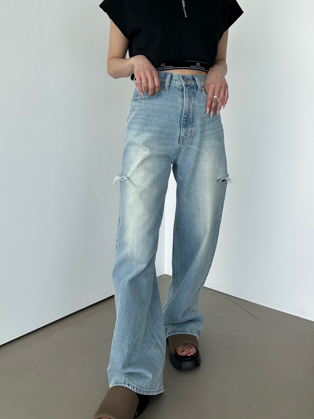 ブルー系のデニムパンツ、ブラック系のタンクトップ、ブラック系のTシャツ/カットソーを着用したレディースの春コーディネートの2枚目の写真