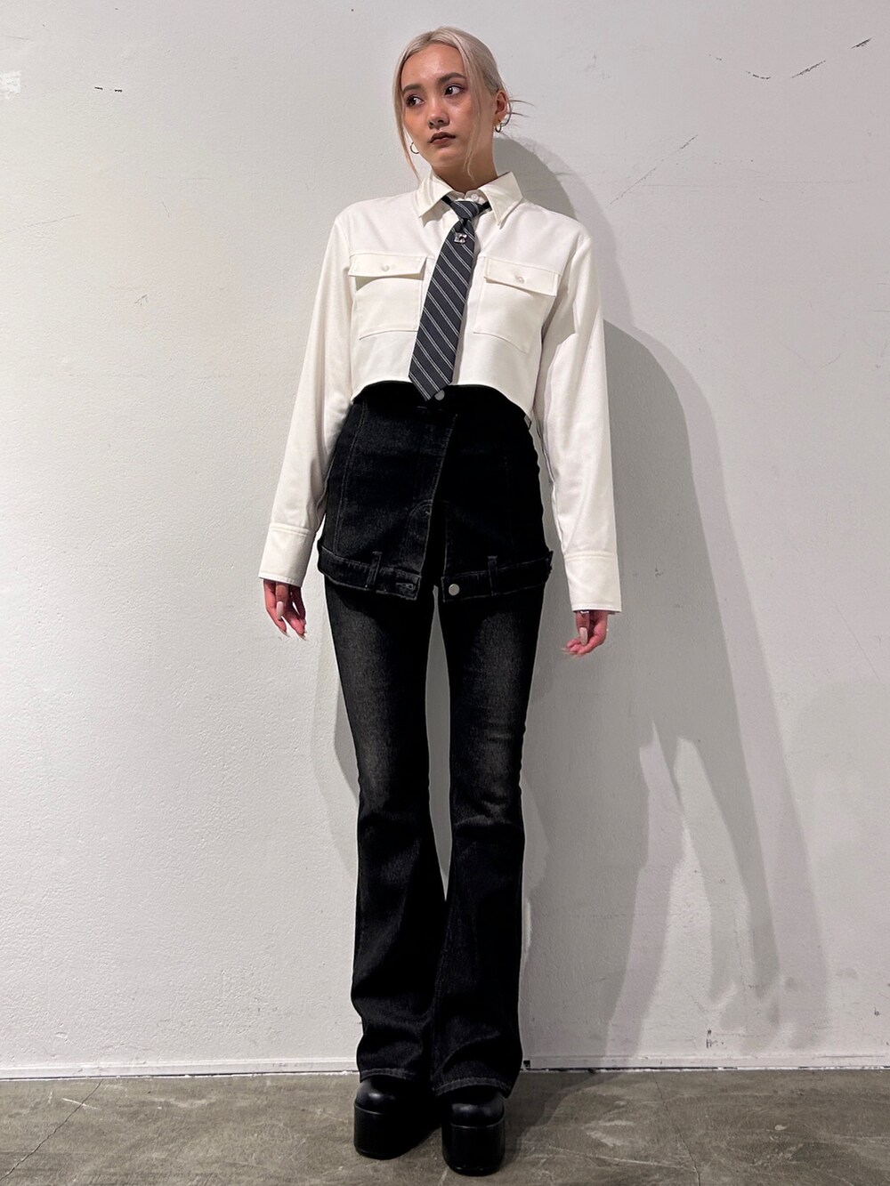 ホワイト系のシャツ/ブラウス、ブラック系のデニムパンツ、ブラック系のブーツを着用したレディースの秋コーディネートの2枚目の写真