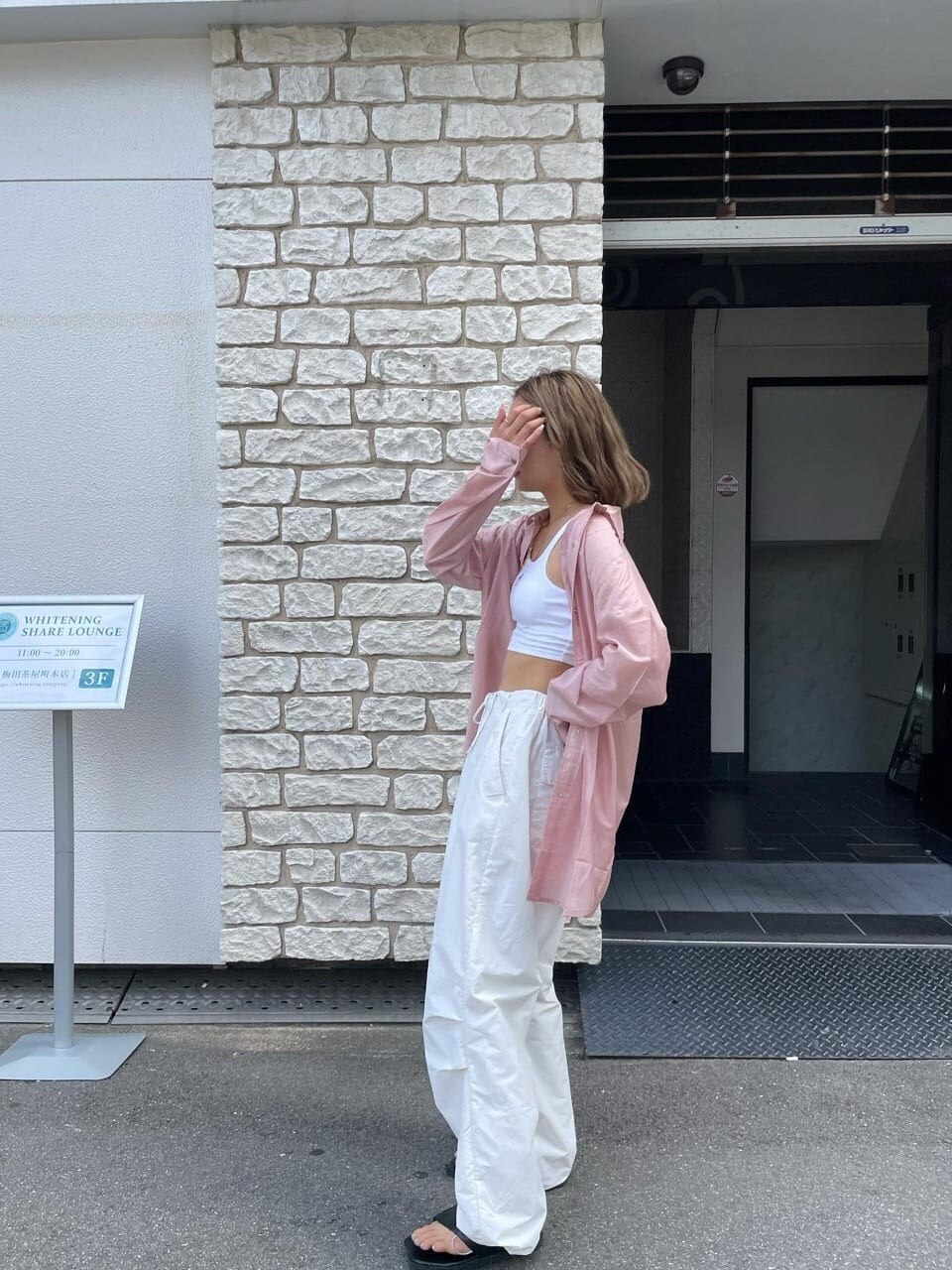 ピンク系のシャツ/ブラウスを着用したレディースの夏コーディネートの2枚目の写真