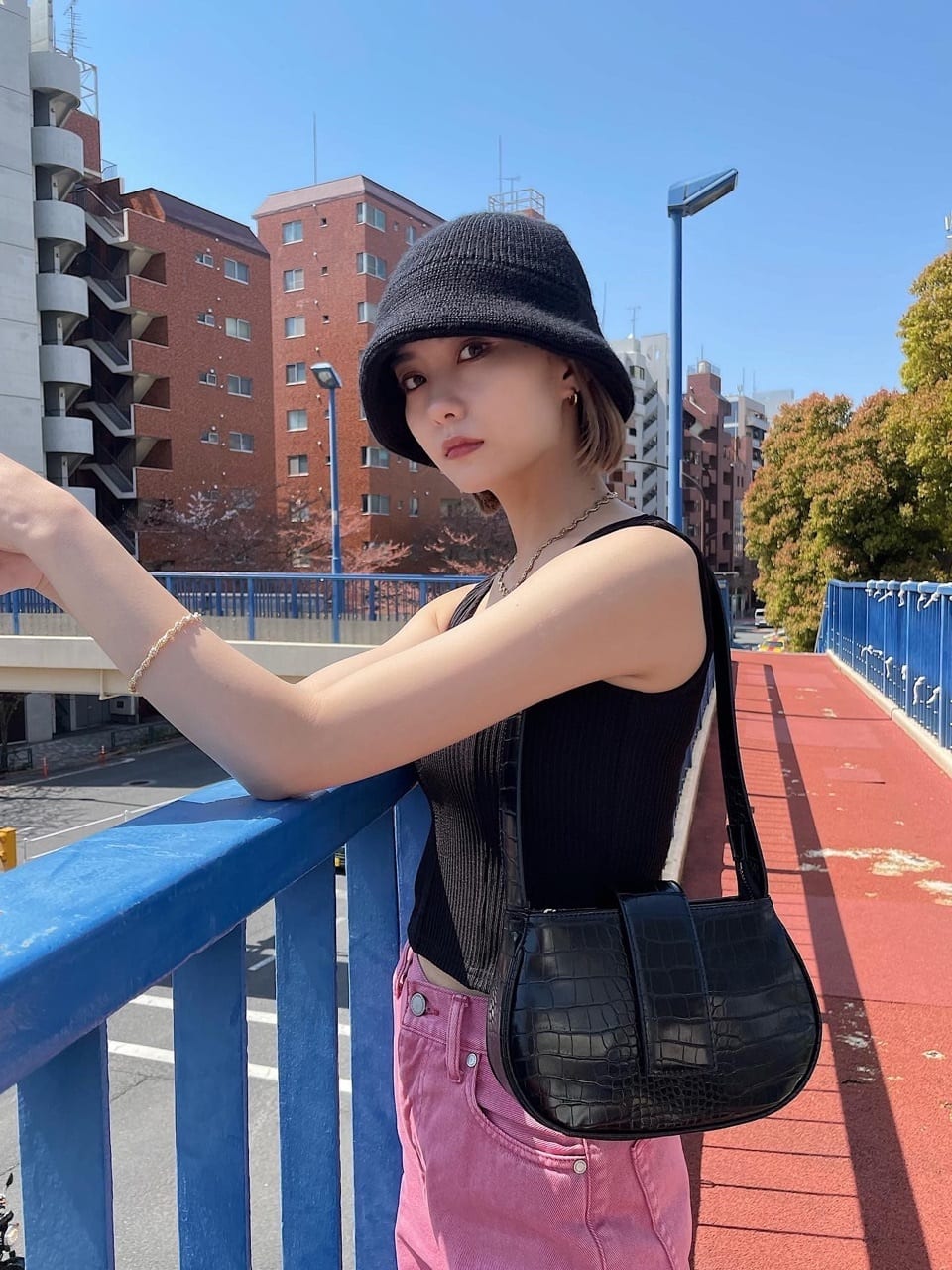 ブラック系のハンドバッグ、ブラック系のタンクトップ、ブラック系のハットを着用したレディースの夏コーディネートの2枚目の写真