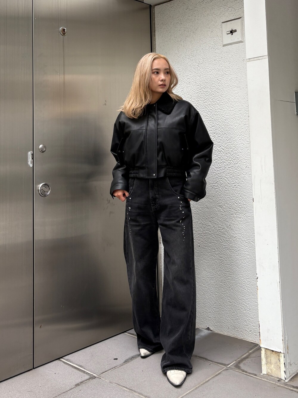 ブラック系のブルゾン、ブラック系のデニムパンツを着用したレディースの秋コーディネートの3枚目の写真