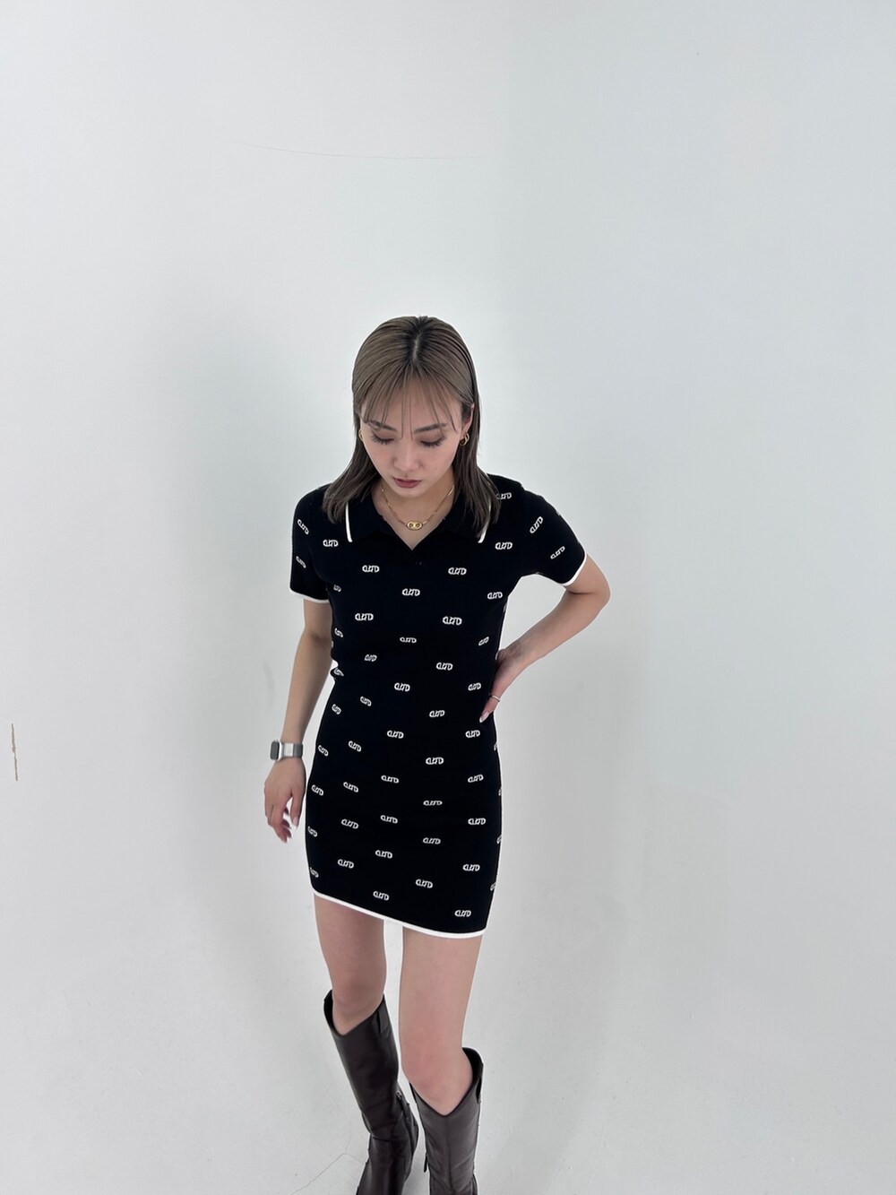 ブラック系のワンピース、ブラック系のブーツを着用したレディースの春コーディネートの5枚目の写真