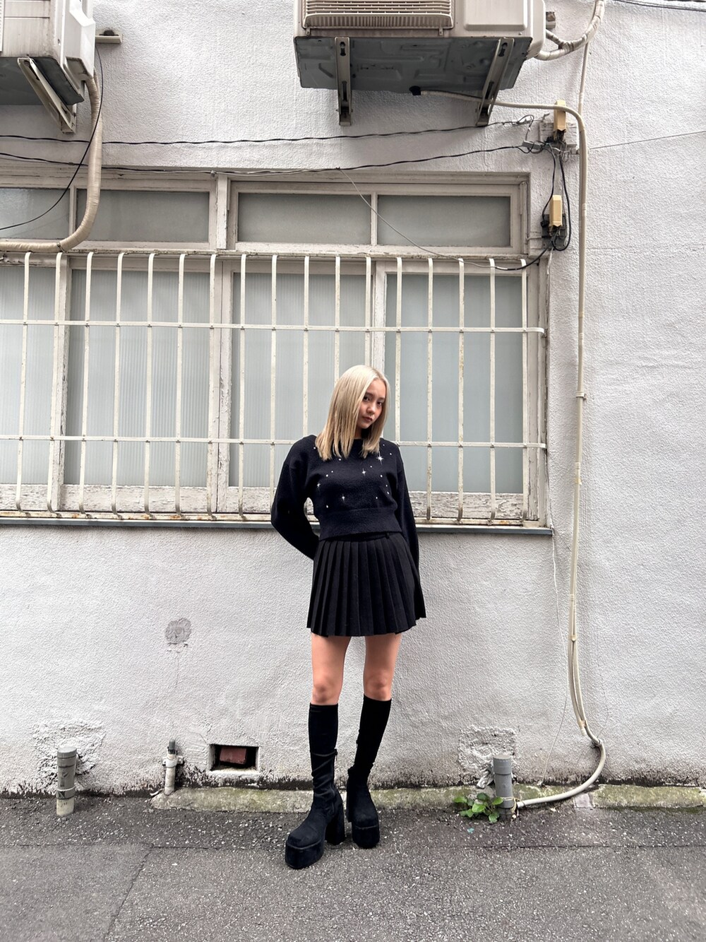 ブラック系のニット/セーター、ブラック系のスカート、その他のブーツを着用したレディースの冬コーディネートの2枚目の写真