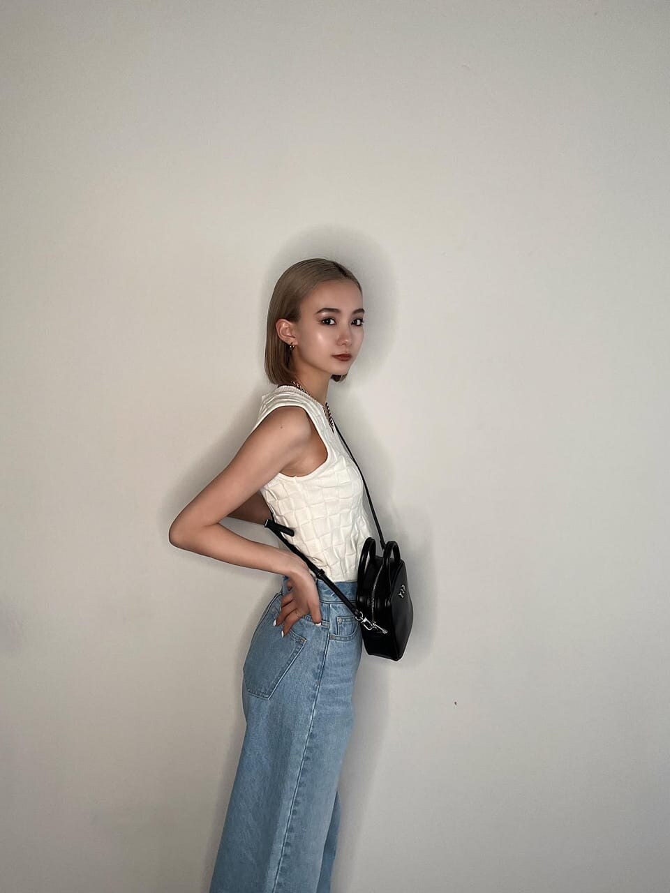 ブルー系のデニムパンツ、ホワイト系のタンクトップを着用したレディースの春コーディネートの2枚目の写真