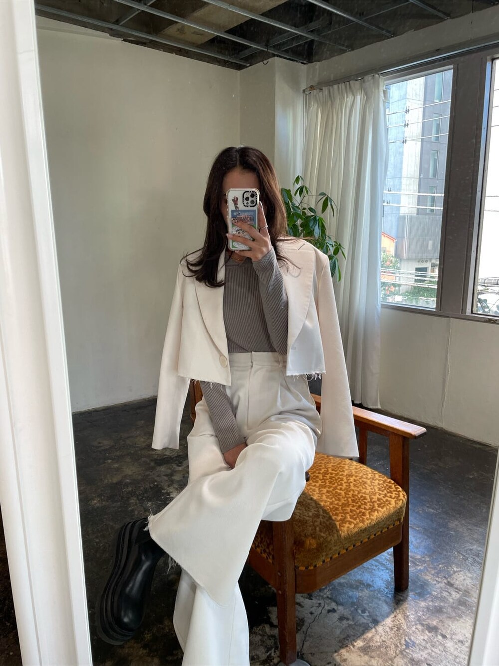 ホワイト系のテーラードジャケット、グレー系のニット/セーターを着用したレディースの冬コーディネートの4枚目の写真