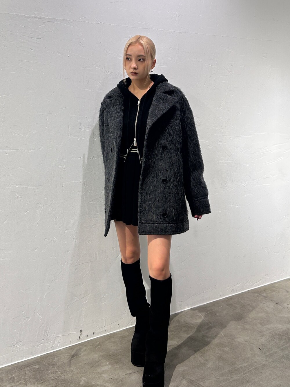 ブラック系のその他アウター、ブラック系のブーツ、グレー系のニット/セーターを着用したレディースの秋コーディネートの2枚目の写真