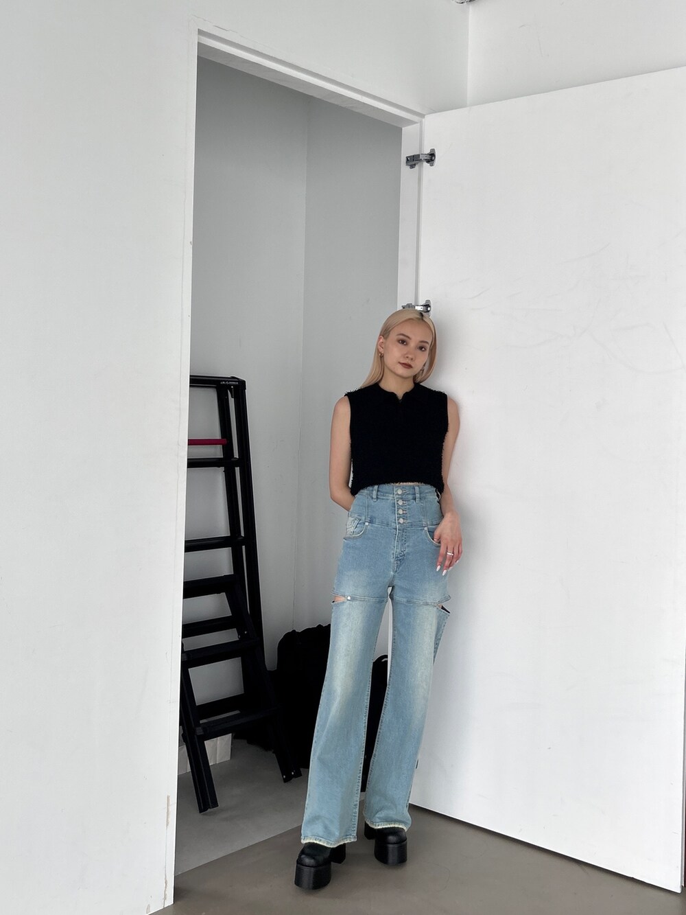 ブラック系のタンクトップ、ブルー系のデニムパンツを着用したレディースの夏コーディネートの3枚目の写真