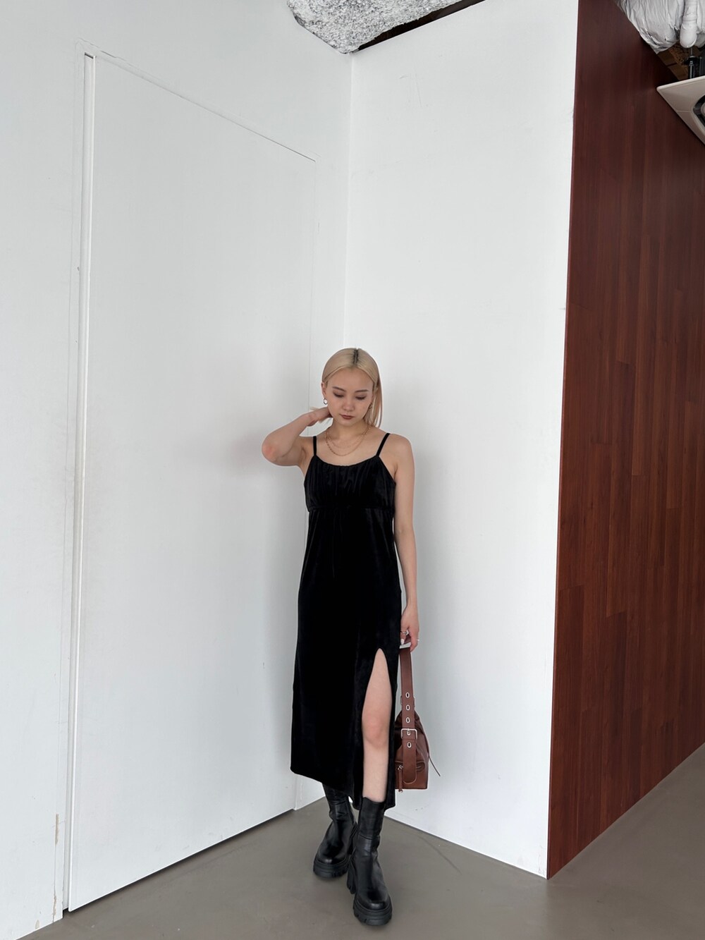 ブラック系のワンピース、ブラウン系のショルダーバッグ、ブラック系のブーツを着用したレディースの夏コーディネートの3枚目の写真