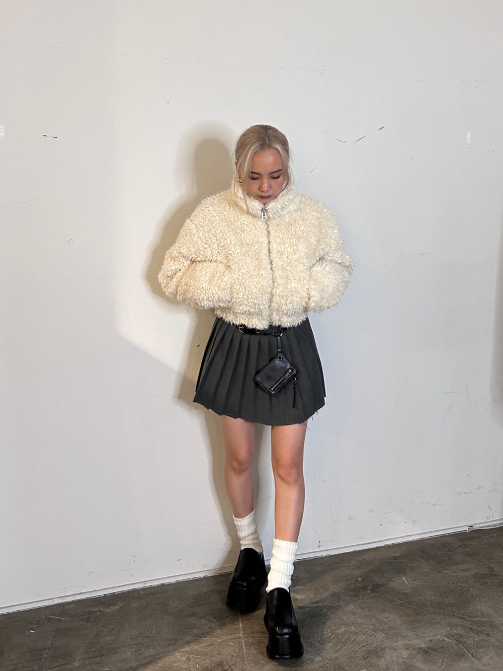 ホワイト系のブルゾン、グレー系のスカート、ブラック系のローファーを着用したレディースの秋コーディネートの3枚目の写真