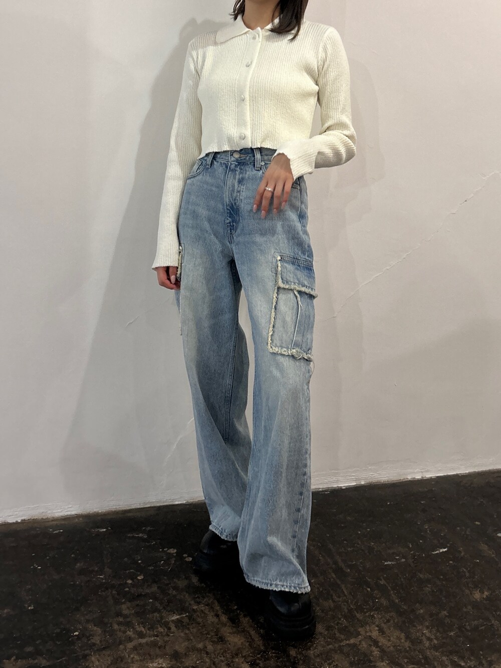 ブルー系のデニムパンツ、ホワイト系のニット/セーターを着用したレディースの春コーディネートの2枚目の写真