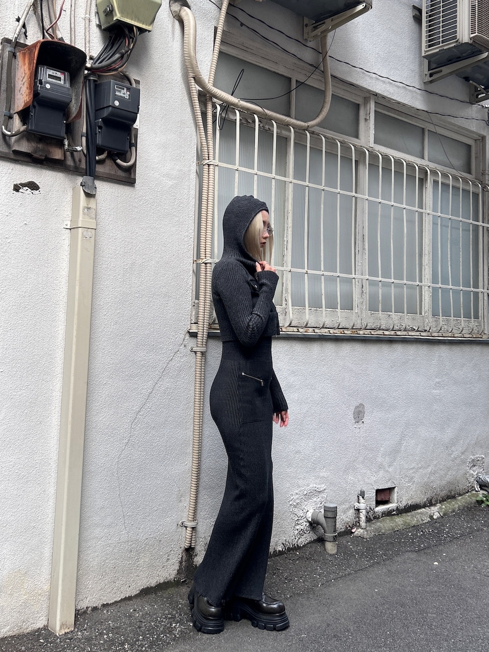 ブラック系のニット/セーター、ブラック系のスカート、ブラック系のブーツを着用したレディースの冬コーディネートの3枚目の写真