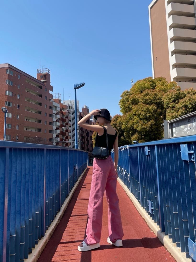 ピンク系のデニムパンツ、ブラック系のタンクトップを着用したレディースの夏コーディネートの2枚目の写真