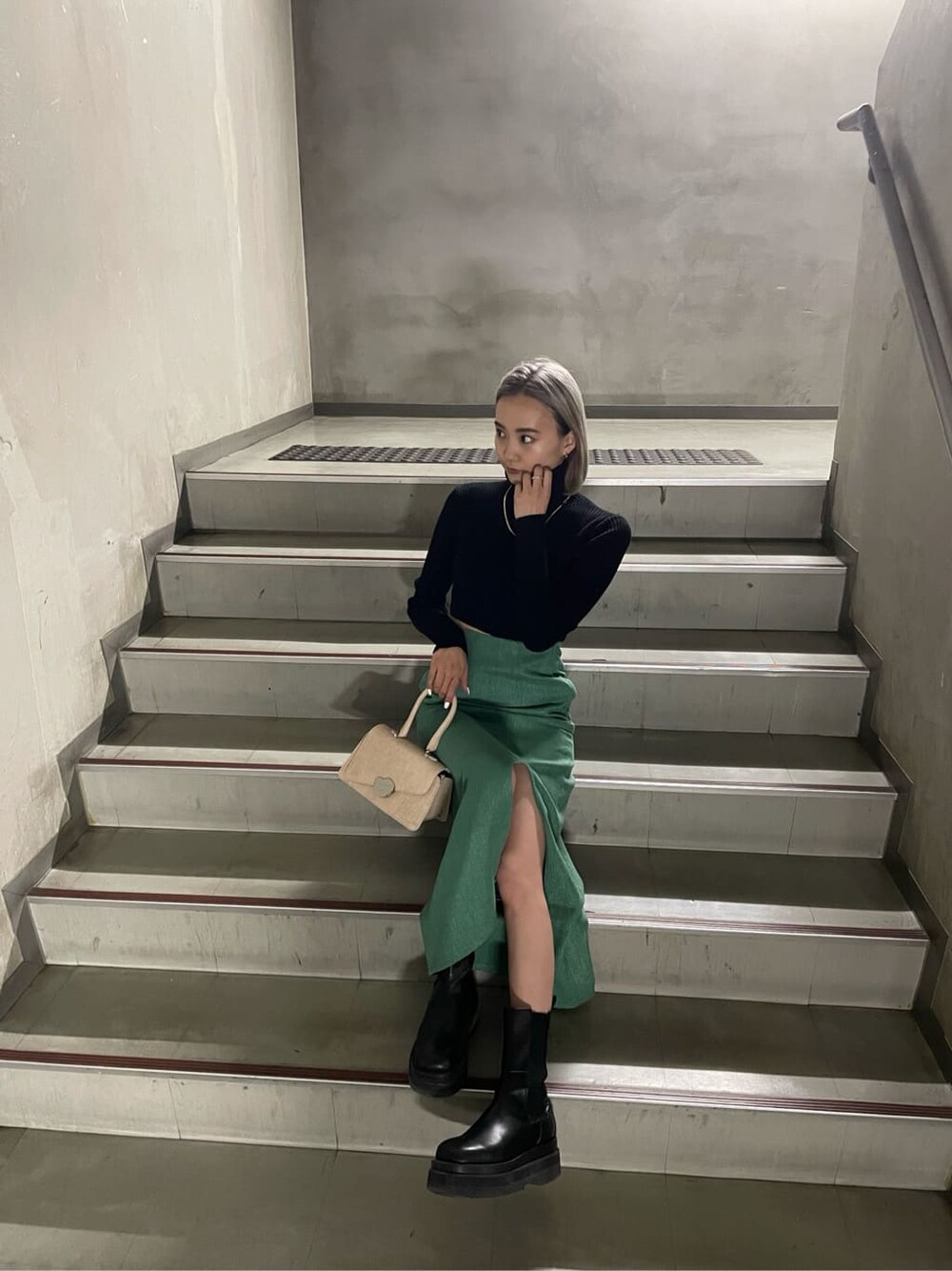 グリーン系のスカート、ブラック系のニット/セーターを着用したレディースの冬コーディネートの3枚目の写真
