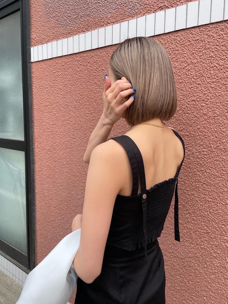 ブラック系のスカート、ブラック系のタンクトップを着用したレディースの春コーディネートの4枚目の写真