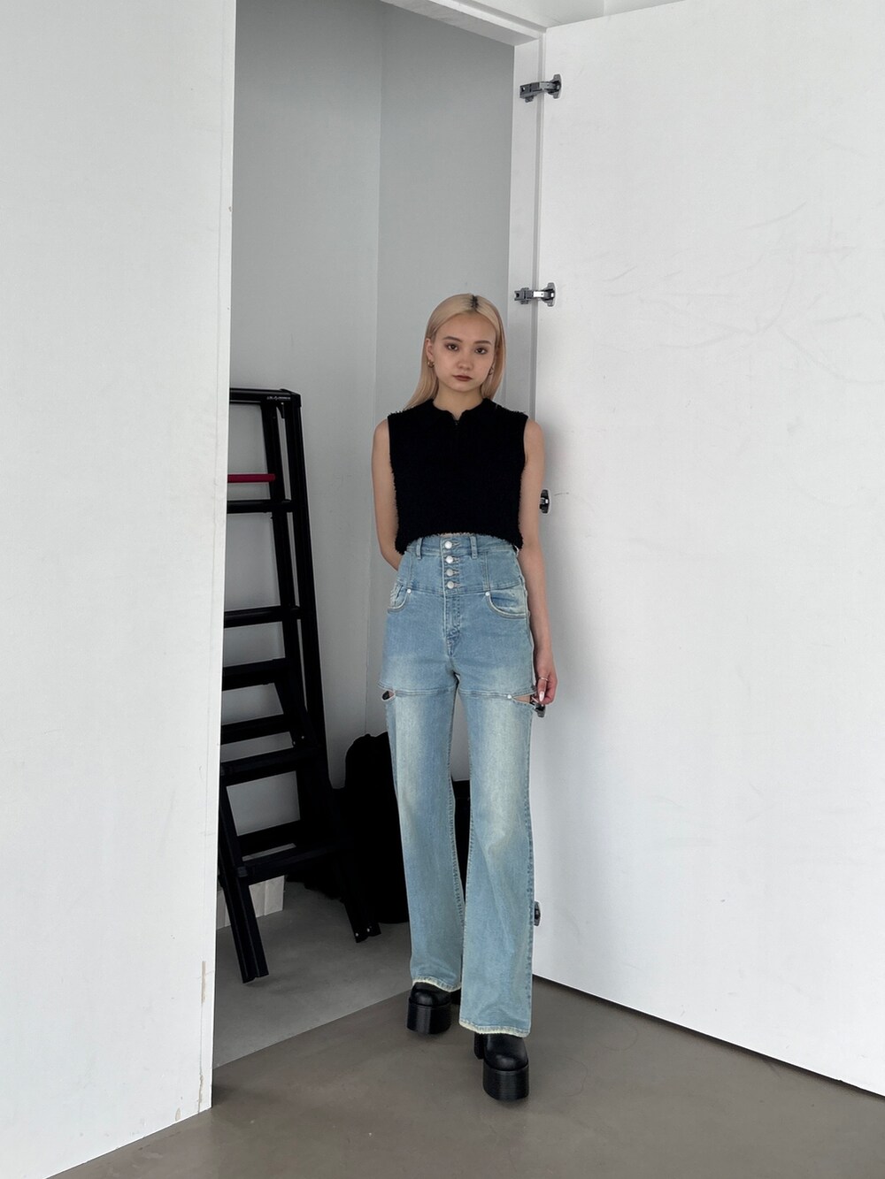 ブラック系のタンクトップ、ブルー系のデニムパンツを着用したレディースの夏コーディネートの4枚目の写真