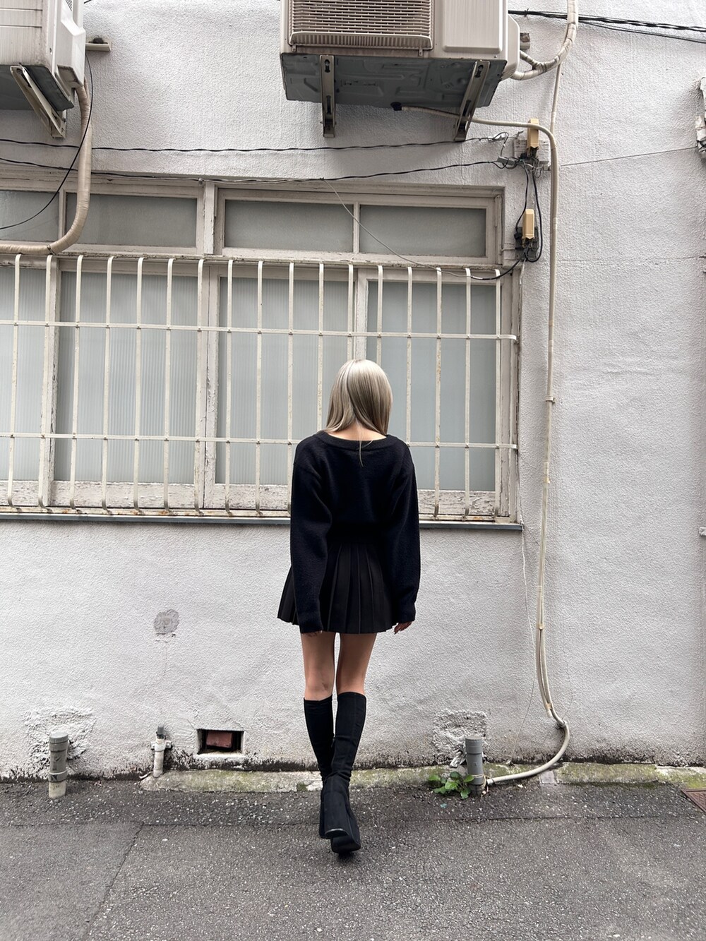 ブラック系のニット/セーター、ブラック系のスカート、その他のブーツを着用したレディースの冬コーディネートの3枚目の写真