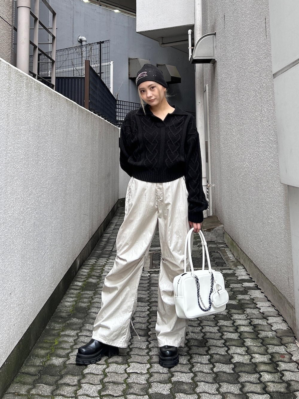 レッド系のニット/セーター、ホワイト系のその他パンツ、ブラック系のブーツを着用したレディースの秋コーディネートの2枚目の写真