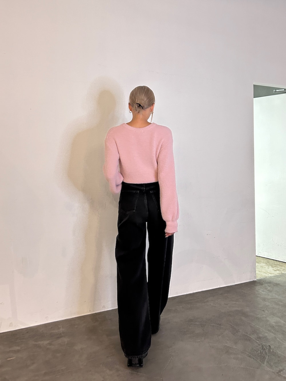 ピンク系のニット/セーター、ブラック系のデニムパンツ、ブラック系のローファーを着用したレディースの秋コーディネートの3枚目の写真