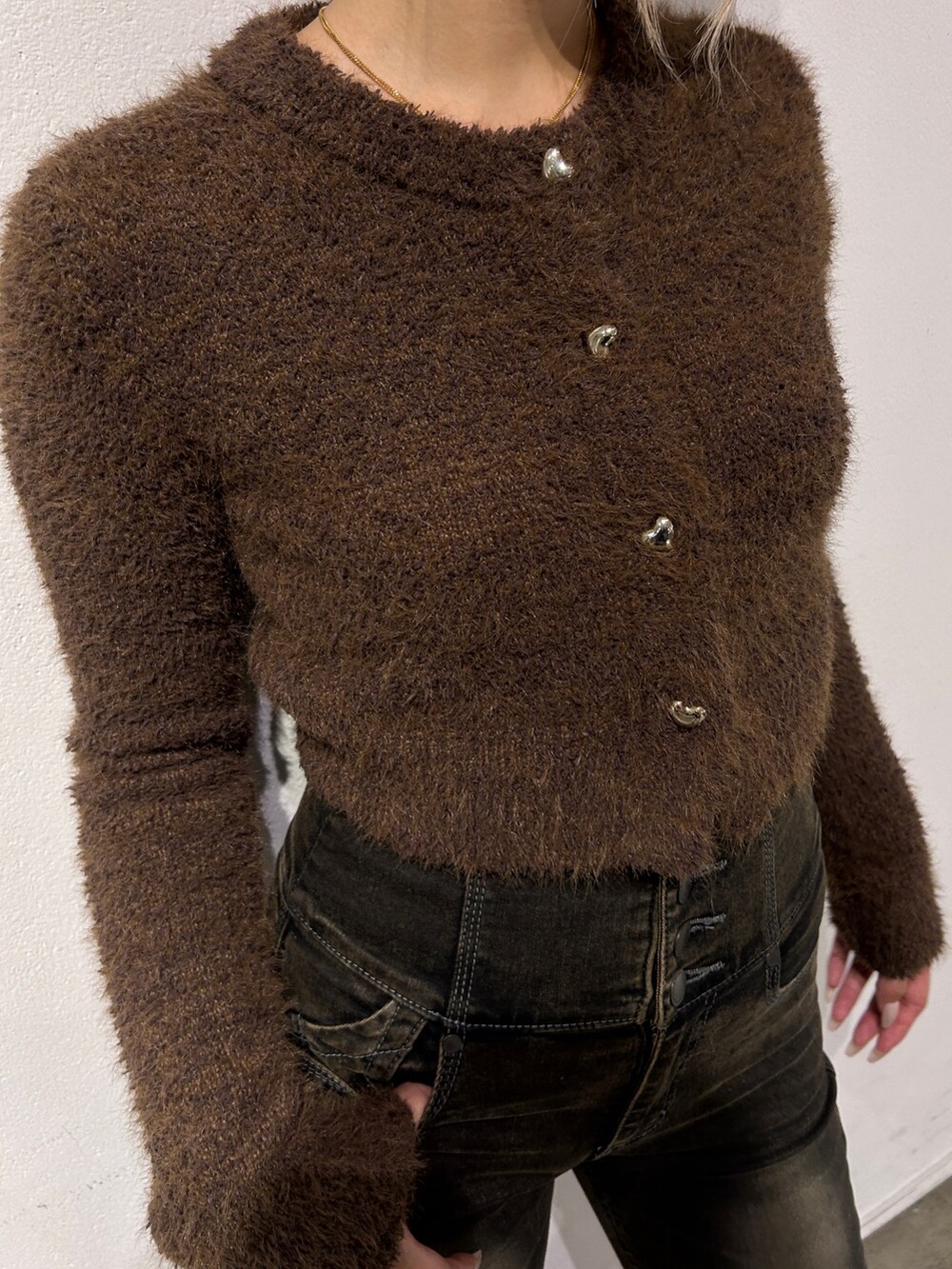 ブラウン系のニット/セーター、ブラック系のデニムパンツ、ブラック系のハンドバッグを着用したレディースの秋コーディネートの4枚目の写真