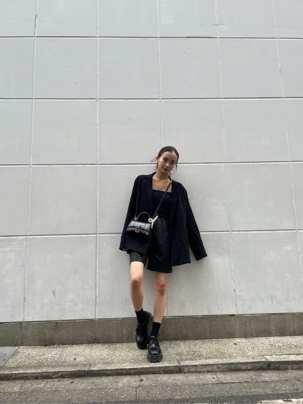 ブラック系のテーラードジャケット、ブラック系のその他パンツ、ブラック系のキャミソールを着用したレディースの秋コーディネートの3枚目の写真