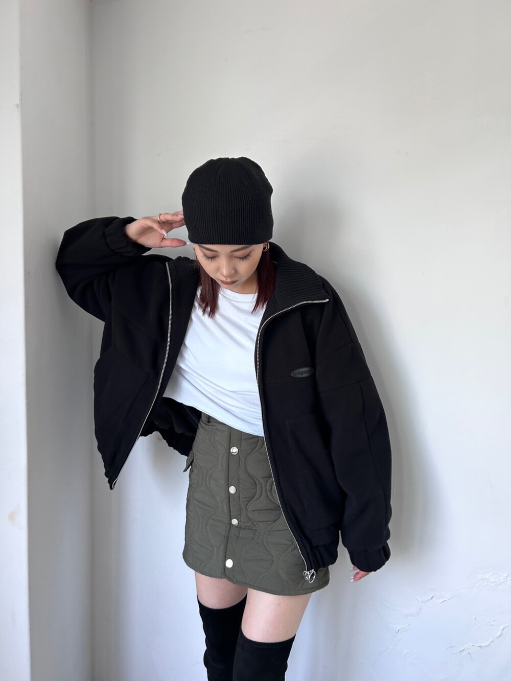 ブラック系のブルゾン、グリーン系のスカート、ホワイト系のTシャツ/カットソーを着用したレディースの秋コーディネートの3枚目の写真