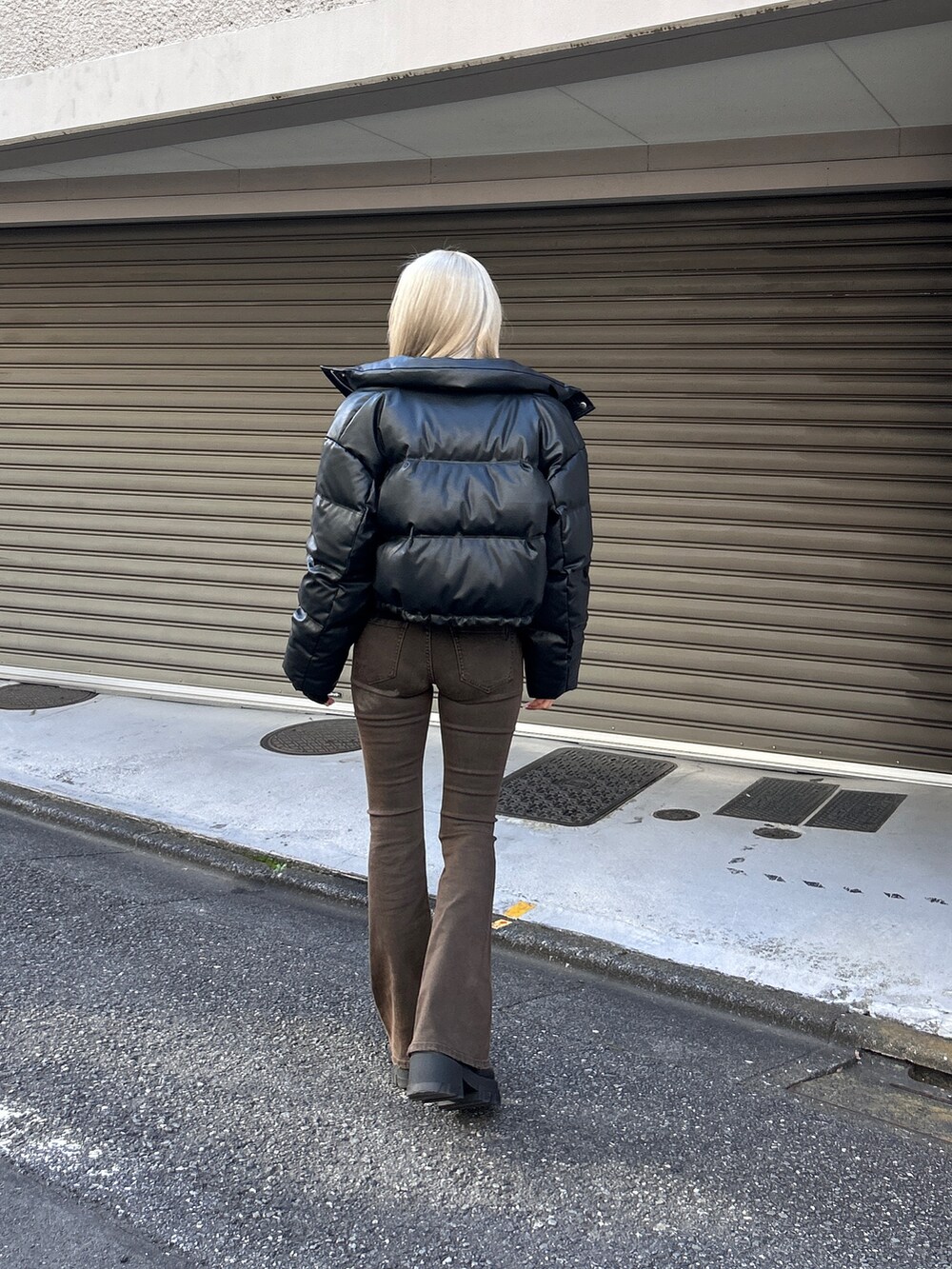 ブラック系のダウンジャケット/コート、ブラック系のデニムパンツ、ブラック系のブーツを着用したレディースの冬コーディネートの2枚目の写真