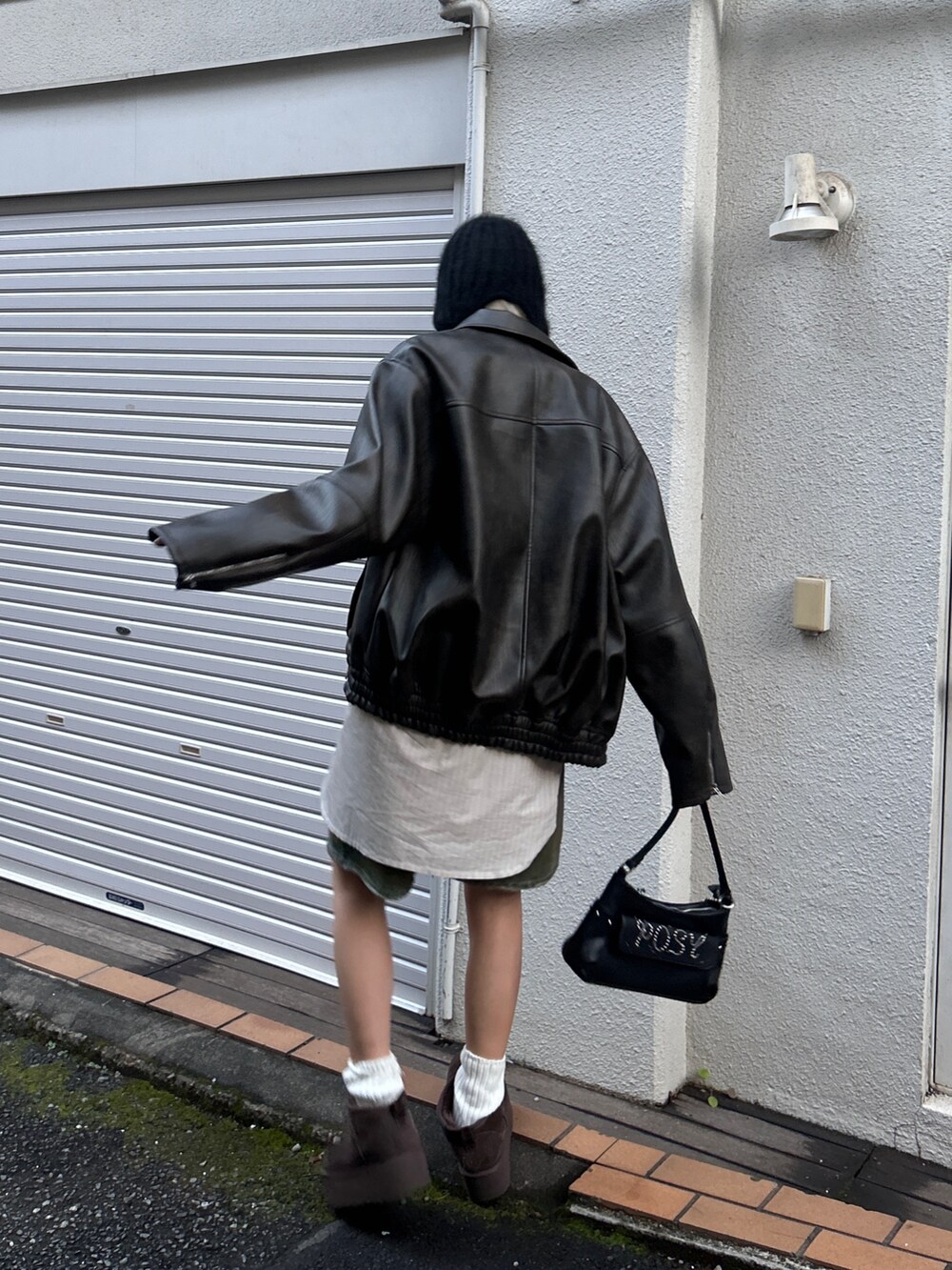 ブラック系のブルゾン、ブラウン系のデニムパンツ、ブラック系のハンドバッグを着用したレディースの冬コーディネートの3枚目の写真